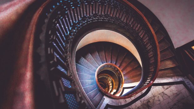 Spiral staircase with metal railing viewed from above showing vintage architecture