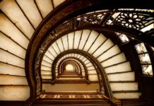 Vintage spiral staircase with ornate railing viewed from below interior design