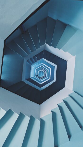 Blue staircase with geometric shapes spiraling upward in a hexagonal pattern
