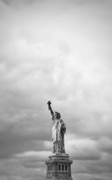 The Statue of Liberty stands tall against a cloudy sky in black and white, HD Mobile Wallpaper