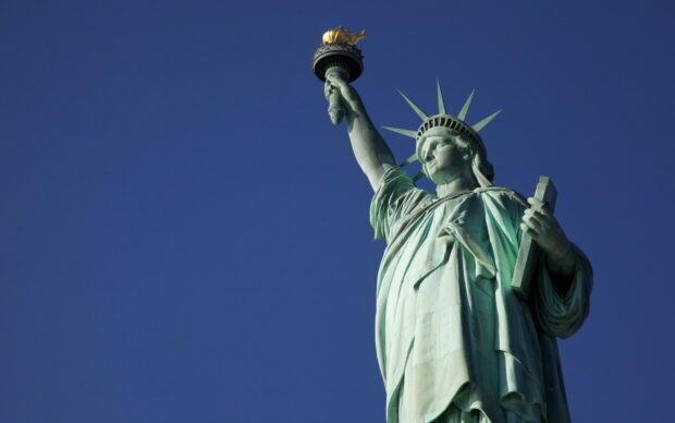 The Statue of Liberty stands tall holding the torch against a clear blue sky, HD Desktop Wallpaper