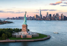 The Statue of Liberty stands tall overlooking the New York City skyline at sunset, HD Desktop Wallpaper