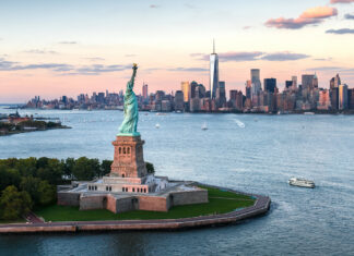 The Statue of Liberty stands tall overlooking the New York City skyline at sunset, HD Desktop Wallpaper