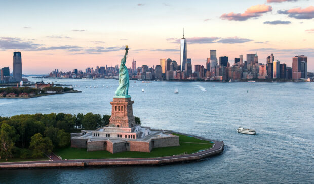 The Statue of Liberty stands tall overlooking the New York City skyline at sunset, HD Desktop Wallpaper