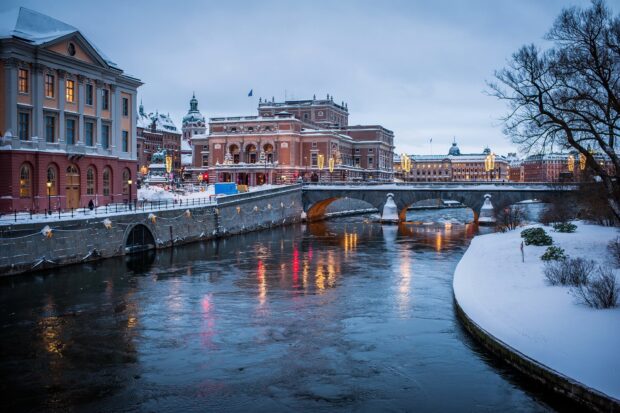 Historic Stockholm street covered with snow along a river in winter
