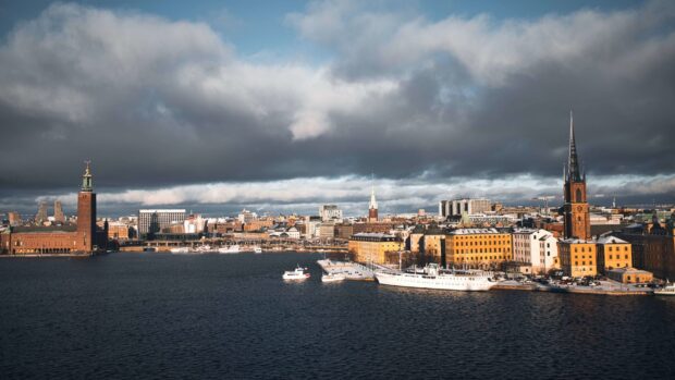 View of Stockholm cityscape with boats and historic buildings under cloudy sky