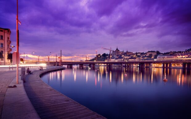 Evening cityscape of Stockholm with calm water and purple sky during sunset