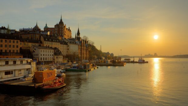 Beautiful old buildings along the waterfront in Stockholm at sunset with calm water reflection