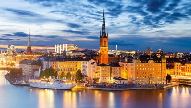 Evening cityscape of Stockholm featuring historic buildings and a boat on the water