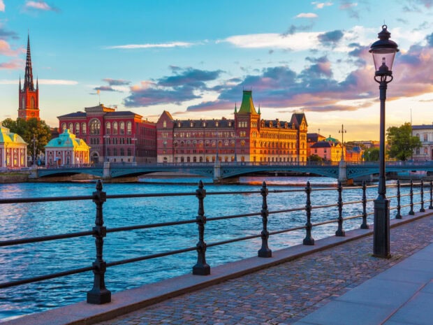 Historic buildings and a bridge over the water in Stockholm during sunset with a clear sky