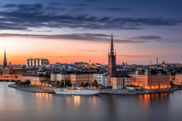 Stockholm cityscape at sunset with historic buildings and a ship on the water