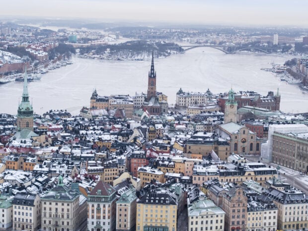 A panoramic view of Stockholm city covered in snow with historic buildings and frozen waterways