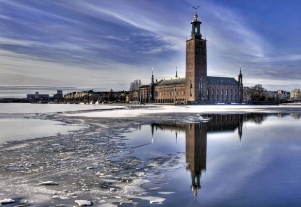 The magnificent Stockholm building with icy waters reflecting the historic tower in winter