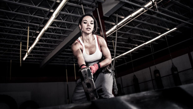 A woman focused on her Crossfit workouts lifting a hammer during training, HD Desktop Wallpaper