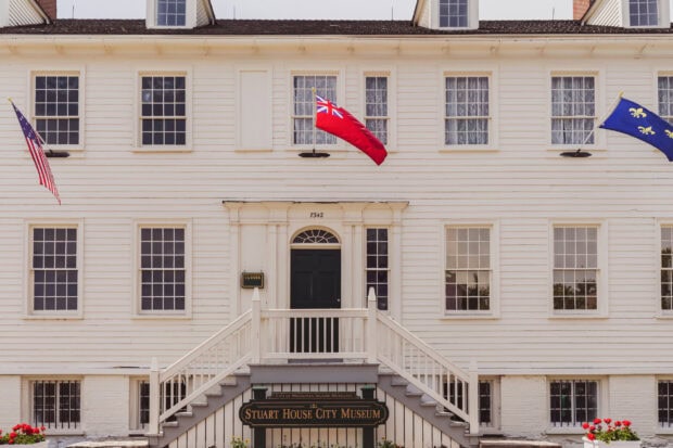 The front view of Stuart House City Museum on Mackinac Island shows American and other flags, HD Desktop Wallpaper
