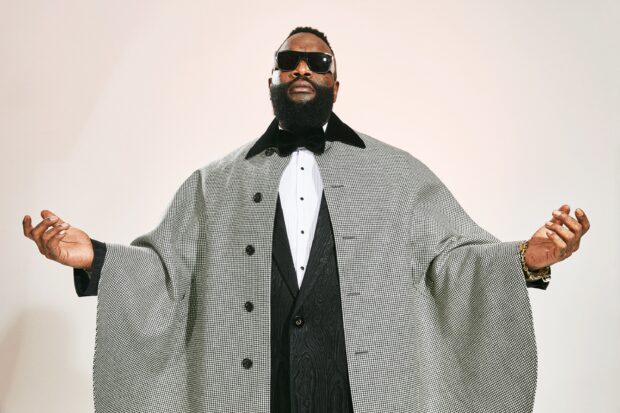 Rick Ross wears an elegant checkered cape and sunglasses while posing confidently, 2K Desktop Wallpaper