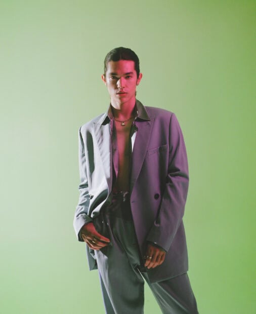 A confident man poses elegantly in a grey suit with green background highlighting Conan Gray wallpapers, HD Desktop Wallpaper