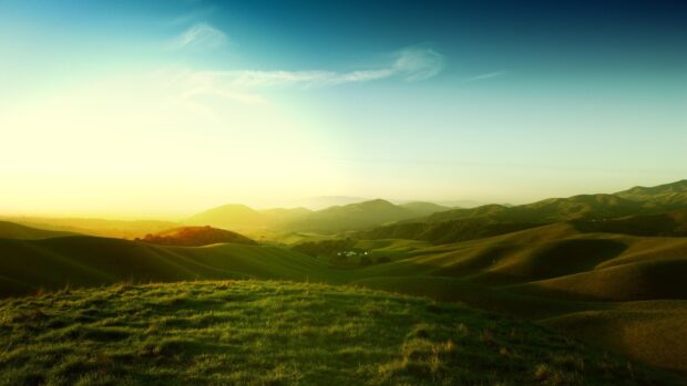 The green hills display a serene landscape under a clear sky at sunset, HD Desktop Wallpaper