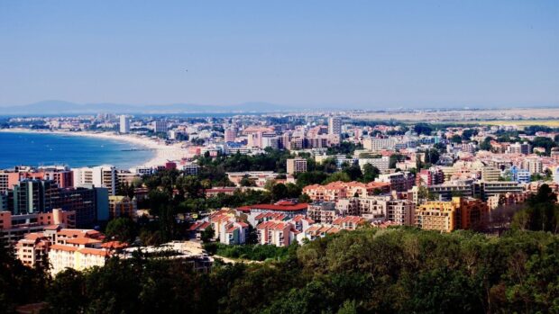 The Bulgaria Wallpapers show a sunny coastline with urban buildings and green areas near the sea, HD Desktop Wallpaper