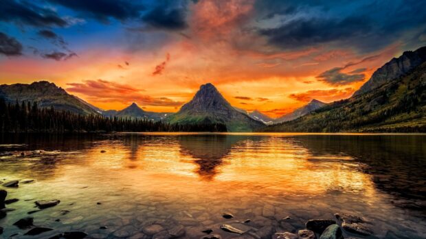 The calm lake reflects the mountain and vibrant sunset at Glacier National Park, 4K Desktop Wallpaper