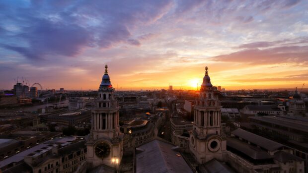 The sun sets behind historic towers in the United Kingdom with clouds above, 4K Desktop Wallpaper