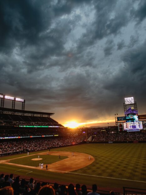 A vibrant sunset illuminates a Major League Baseball game with players and crowd visible, HD Mobile Wallpaper