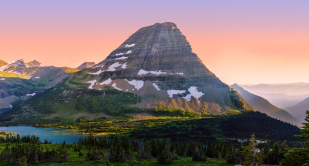 The mountain in Glacier National Park is seen against a pink sunset sky, HD Desktop Wallpaper