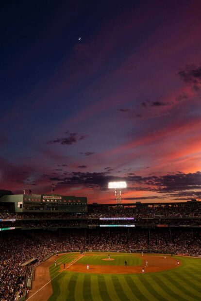 A baseball game is taking place in a stadium under a colorful sunset sky in the Major League Baseball scene, HD Mobile Wallpaper