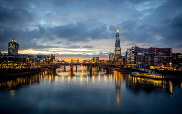 The River Thames captures the city lights and calm waters at sunset with iconic buildings, 2K Desktop Wallpaper