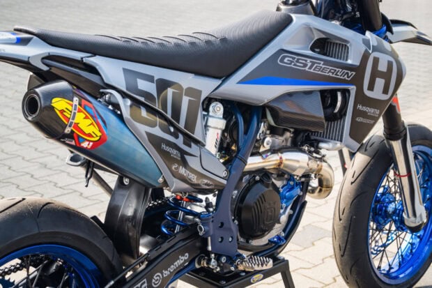 Close up of a supermoto bike engine and exhaust system in grey and blue colors