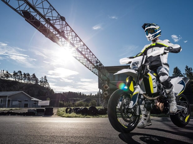 Rider on a supermoto bike preparing for a race under bright sunlight