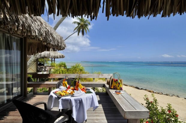 Tropical paradise with a wooden terrace featuring fresh fruit and drinks in Tahiti