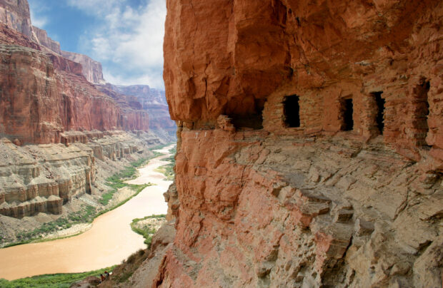 Ancient cliff dwellings overlooking the Colorado River winding through a deep canyon