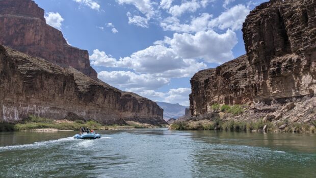 A scenic view of the Colorado River flowing between towering canyon walls