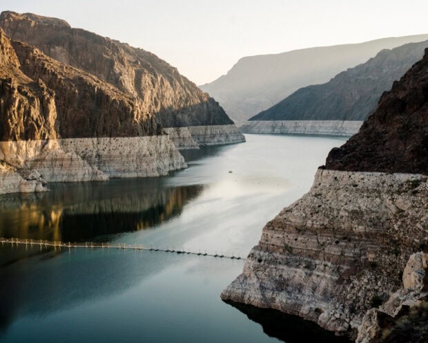 Rocky canyon cliffs surrounding the Colorado River under soft sunlight