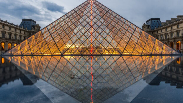 The Louvre glass pyramid geometric structure glowing at dusk