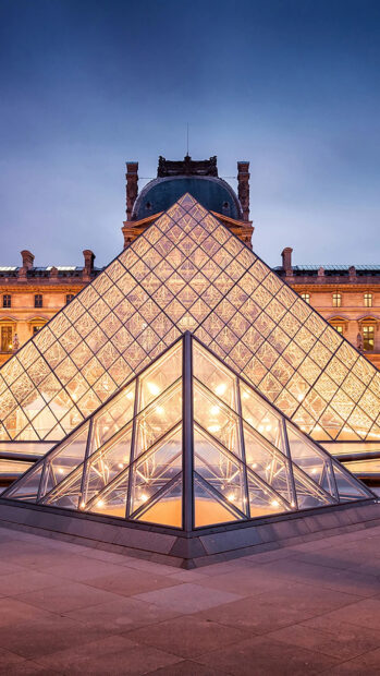 The Louvre pyramid illuminated at night in Paris France