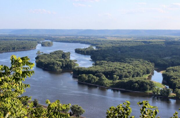 A wide view of the Mississippi River flowing through lush green forests under a clear sky, HD Desktop Wallpaper