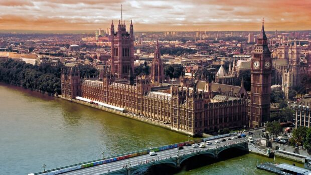 The River Thames features historic buildings and a busy bridge in this detailed cityscape, 4K Desktop Wallpaper