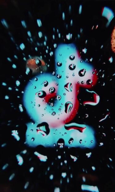 Close up of water droplets reflecting tiktok logo in vibrant colors
