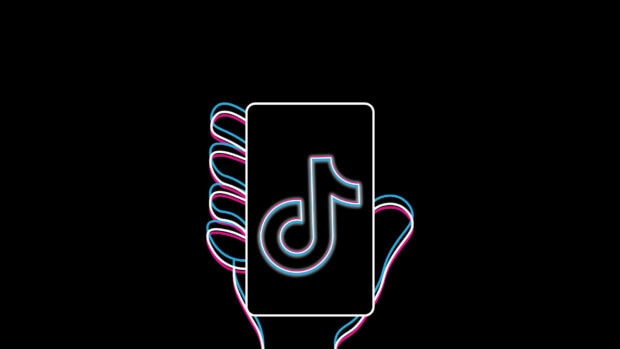 A neon outline of a hand holding a phone with the tiktok logo glowing in blue and pink