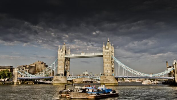 The River Thames flows under Tower Bridge on a cloudy day with boats on the water, 4K Desktop Wallpaper