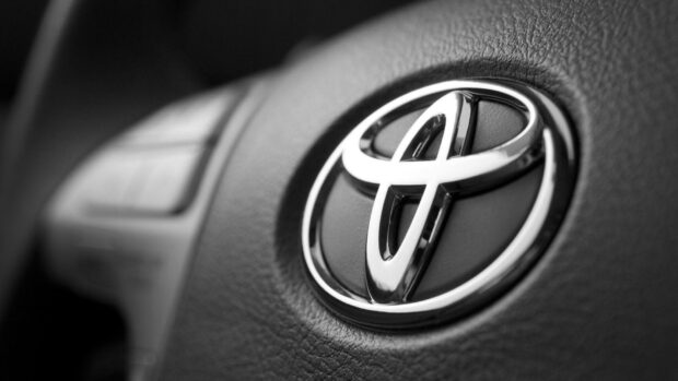 Toyota logo on car steering wheel in black and white.