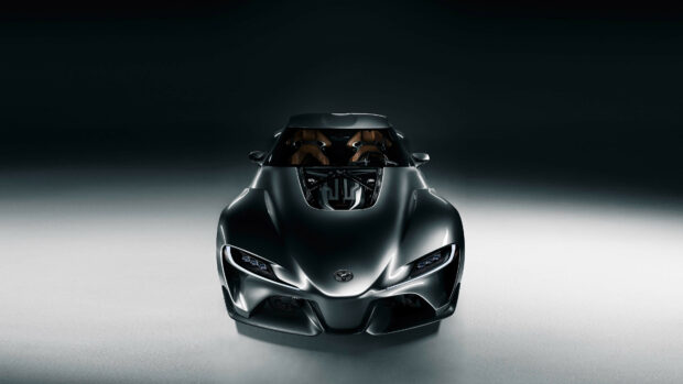 Futuristic black sports car with sleek aerodynamic design and exposed engine, showcased on a minimalistic dark background.