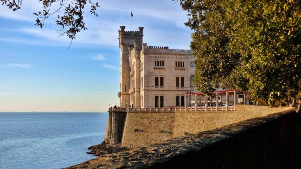 A historic castle stands on the coast with clear skies in Trieste Wallpapers, HD Desktop Wallpaper