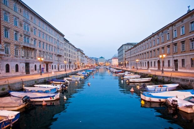 A peaceful canal in Trieste with boats and historic buildings along the water, HD Desktop Wallpaper
