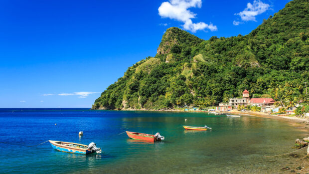 A bright day on Dominica Island with boats floating near the lush green coast, HD Desktop Wallpaper