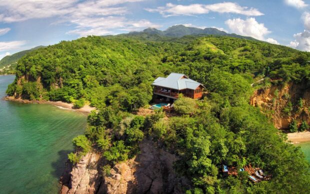 A secluded house sits among lush greenery on Dominica Island surrounded by sea and cliffs, HD Desktop Wallpaper