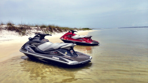 A black and a red jet ski parked calmly on a beach with clear water, HD Desktop Wallpaper