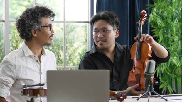 A man is holding a violin while talking about violin wallpapers, 4K Desktop Wallpaper